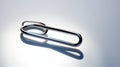Close-up Of Chrome Paperclip On White Surface Royalty Free Stock Photo