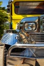 Close-up on the chrome radiator grille, headlight bumper and mud guard of a filipino Jeepney in the Philippines.