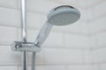 Close-up of chrome shower in the bathroom covered decorative ceramic tiles with white glossy bricks. Royalty Free Stock Photo