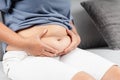 Close up of chubby woman holding her belly fat on the sofa. Diet lifestyle to reduce belly and shape up healthy abdominal muscle Royalty Free Stock Photo