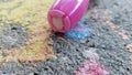 Close up of chunky pink kid chalk on drive way social distancing activity at home