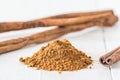 Close-up of cinnamon powder and cinnamon sticks on white wood Royalty Free Stock Photo