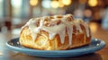 Close-up of a cinnamon roll with icing on a blue plate Royalty Free Stock Photo