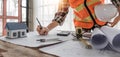 Close up of civil male engineer asian working on blueprint architectural project at construction site at desk in office. Royalty Free Stock Photo