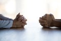 Close up clasped female hands of two businesswomen negotiate at table