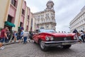 Close-up of a classic American car in Cuba with buildings in the background and famous local
