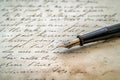 Close-up of a classic fountain pen on aged handwritten letter, ideal for historical documents, romantic correspondence Royalty Free Stock Photo