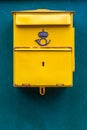 Close up of a classic yellow public postal mail box with a mail symbo.