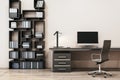 Close up of clean designer office interior with creative wooden bookcase, empty computer monitor and other items. Royalty Free Stock Photo