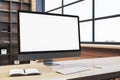 Close up of clean designer office workplace with empty white computer monitor, window with city view and wooden shelves in the Royalty Free Stock Photo