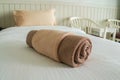 Clean neat towel in roll on white bed in luxury hotel Royalty Free Stock Photo