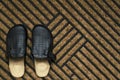 Close up of clean new doormate and house slippers on it.Empty space for text Royalty Free Stock Photo