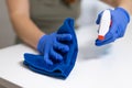 Close up of cleaning white table, sanitizing table surface with disinfectant antibacterial spray bottle, washing Royalty Free Stock Photo