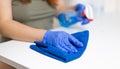 Close up of cleaning white table, sanitizing table surface with disinfectant antibacterial spray bottle, washing Royalty Free Stock Photo