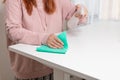 Close up of cleaning white table, sanitizing table surface with disinfectant antibacterial spray bottle, washing Royalty Free Stock Photo