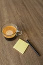 Clear Coffee Mug with Hot Coffee Sticky Note Pad and Black Pen on Wood Desk