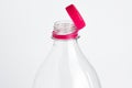 Close-up of a clear plastic bottle with a bright pink cap against a white background Royalty Free Stock Photo