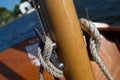 Close up of the cleats on the wooden mast of a small sailing boat dinghy