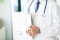 Close-up of clipboard with blank paper in medical doctor hand. Male doctor listens to the patient holding a clipboard Royalty Free Stock Photo