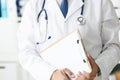 Close-up of clipboard with blank paper in medical doctor hand. Male doctor listens to the patient holding a clipboard Royalty Free Stock Photo