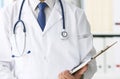 Close-up of clipboard with blank paper in medical doctor hand. Male doctor listens to the patient holding a clipboard Royalty Free Stock Photo