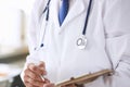 Close-up of clipboard with blank paper in medical doctor hand. Male doctor listens to the patient holding a clipboard Royalty Free Stock Photo