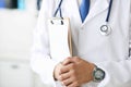 Close-up of clipboard with blank paper in medical doctor hand. Male doctor listens to the patient holding a clipboard Royalty Free Stock Photo