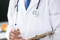 Close-up of clipboard with blank paper in medical doctor hand. Male doctor listens to the patient holding a clipboard Royalty Free Stock Photo