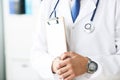 Close-up of clipboard with blank paper in medical doctor hand. Male doctor listens to the patient holding a clipboard Royalty Free Stock Photo