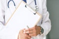 Close-up of clipboard with blank paper in medical doctor hand. Male doctor listens to the patient holding a clipboard Royalty Free Stock Photo