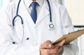Close-up of clipboard with blank paper in medical doctor hand. Male doctor listens to the patient holding a clipboard Royalty Free Stock Photo