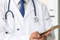 Close-up of clipboard with blank paper in medical doctor hand. Male doctor listens to the patient holding a clipboard Royalty Free Stock Photo