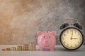 Close-up of clock and pink piggy bank smile with coins stack stair step up growing growth saving money. concept Business Finance, Royalty Free Stock Photo