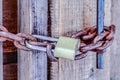 Close up of closed old outdoor bathroom door with padlock and rusty metal chain Royalty Free Stock Photo