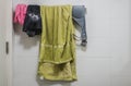 Clothes, brassiere and green towel on hanging rack in bathroom Royalty Free Stock Photo