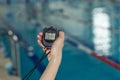 Close-up of coach hand holding stopwatch at poolside