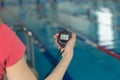 Close-up of coach hand holding stopwatch at poolside