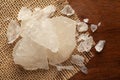 Close-up of coarse Fitkari potassium alum on the wooden top background and jute mat.