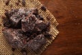 Close-up of coarse Himalayan Black Salt sodium chloride edible on the wooden top background and jute mat.