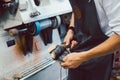 Close-up of cobbler working on pair of shoes with machine