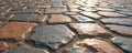 Close-up of cobblestone road with gray, brown stones. Irregularly shaped stones arranged in pattern on ground. Sunlight reflects Royalty Free Stock Photo