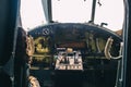 A close up of the cockpit of a vintage airplane. The steering wheel, dashboard, seat and climb levers are visible. Decommissioned