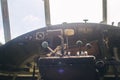 A close up of the cockpit of a vintage airplane. The steering wheel, dashboard, seat and climb levers are visible. Decommissioned