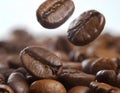 Close-up of coffee beans falling into a pile of coffee beans on a white background with varying shapes and sizes, and intense Royalty Free Stock Photo