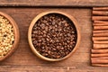 Close up of coffee beans in wooden bowl and cinnamon Royalty Free Stock Photo