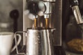 Close-up of coffee from a coffee machine. The coffee machine fills a metal cup with espresso. Professional coffee Royalty Free Stock Photo