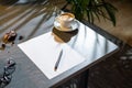 Close up of coffee cup, cookies, glasses, blank sheet of paper and pen on table Royalty Free Stock Photo