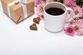 Close up of coffee cup, flowers, sweets, gift box on white background top view, copy space Royalty Free Stock Photo