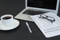 Cup of coffee, laptop, spectacles, newspaper and pen on black background Royalty Free Stock Photo