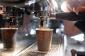 Close-up of a coffee machine making an espresso. The coffee flows into a paper cup under the metal spout of the coffee Royalty Free Stock Photo